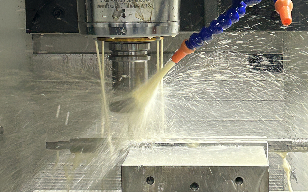 CNC 3‑axis turning machine cutting metal part with coolant in workshop